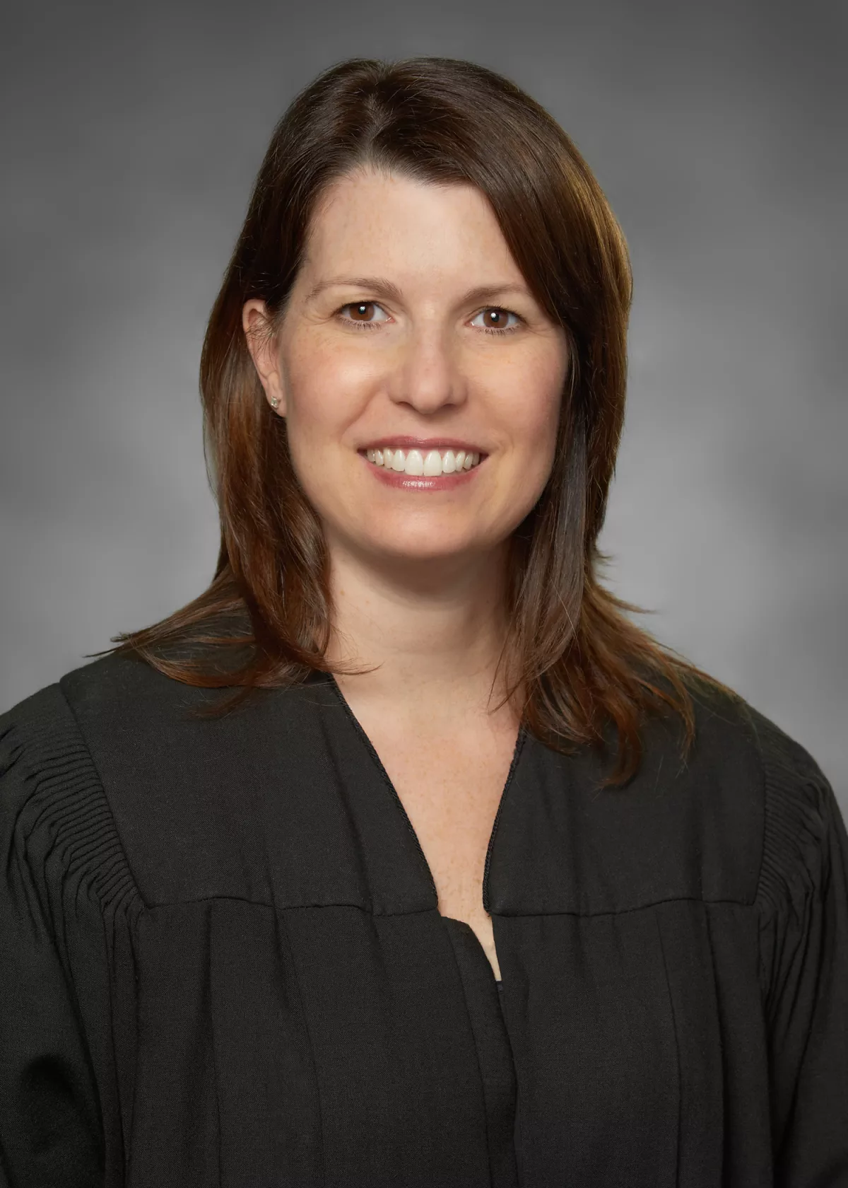 Judge Marian Gaston headshot in robes in front of a grey backdrop.