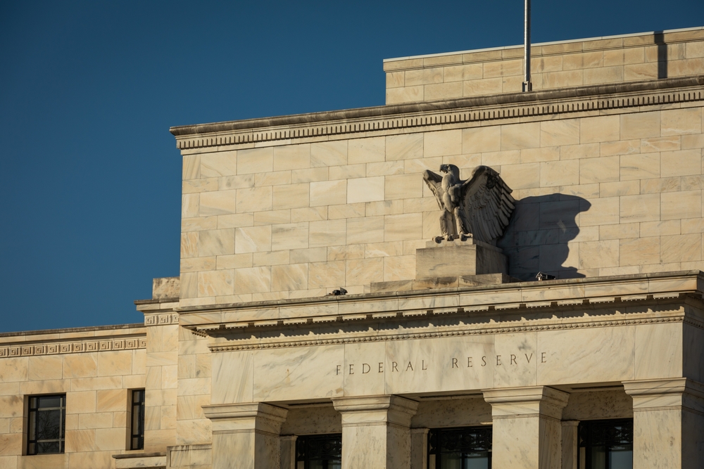 A view of the Federal Reserve building with its eagle statue perched atop columns.