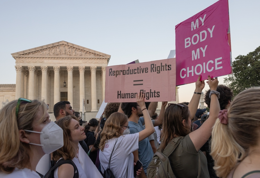 Abortion rights protesters outside the Supreme Court hold signs that say "My Body My Choice" and "Reproductive Rights = Human Rights"